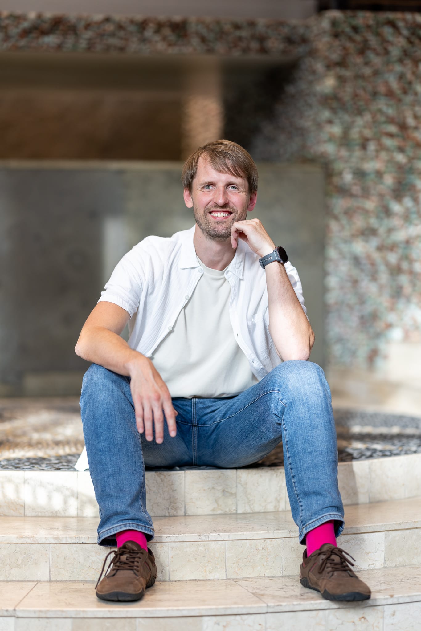 Rytis Luko smiling, seated on stone steps